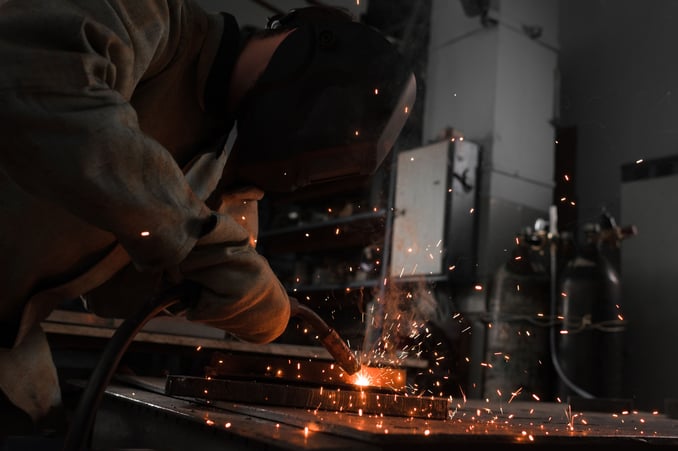 manufacture-worker-welding-metal-with-sparks